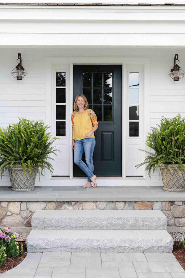  Lauren Walsh on her front stoop, framed by potted ferns from Snug Harbor Farm. Exterior lights were sourced from Nauset Lantern Shop in Massachusetts. 