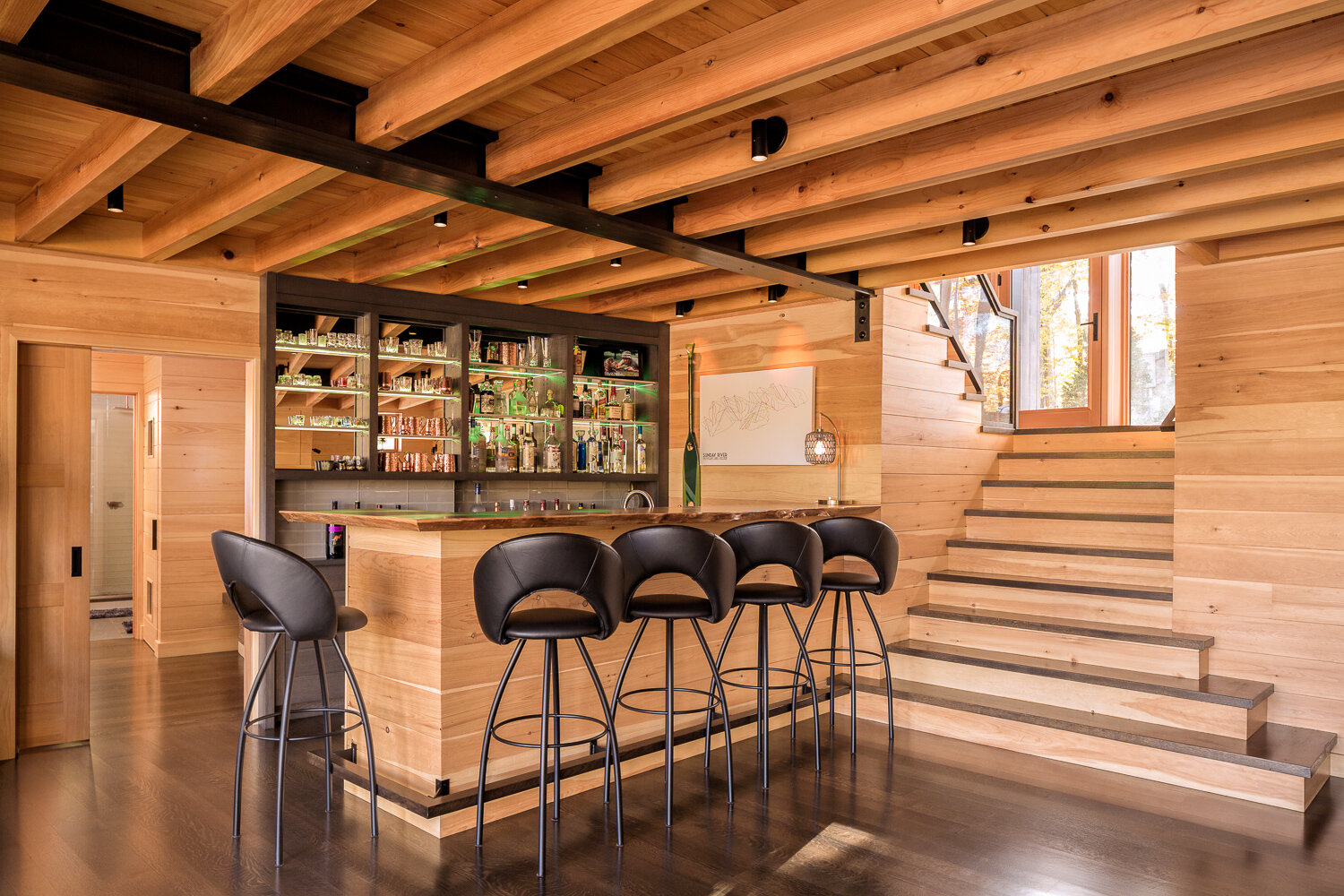  Woodworker Robie Wentworth made the built-ins throughout the house, including the ground-floor bar, which has an English elm countertop and adjustable illuminated glass shelves. 