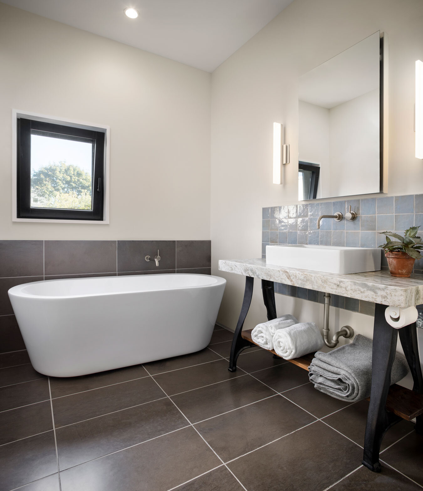  The master bath soaking tub is paired with a console made from vintage worktable legs, found on Etsy, and a natural stone countertop. 