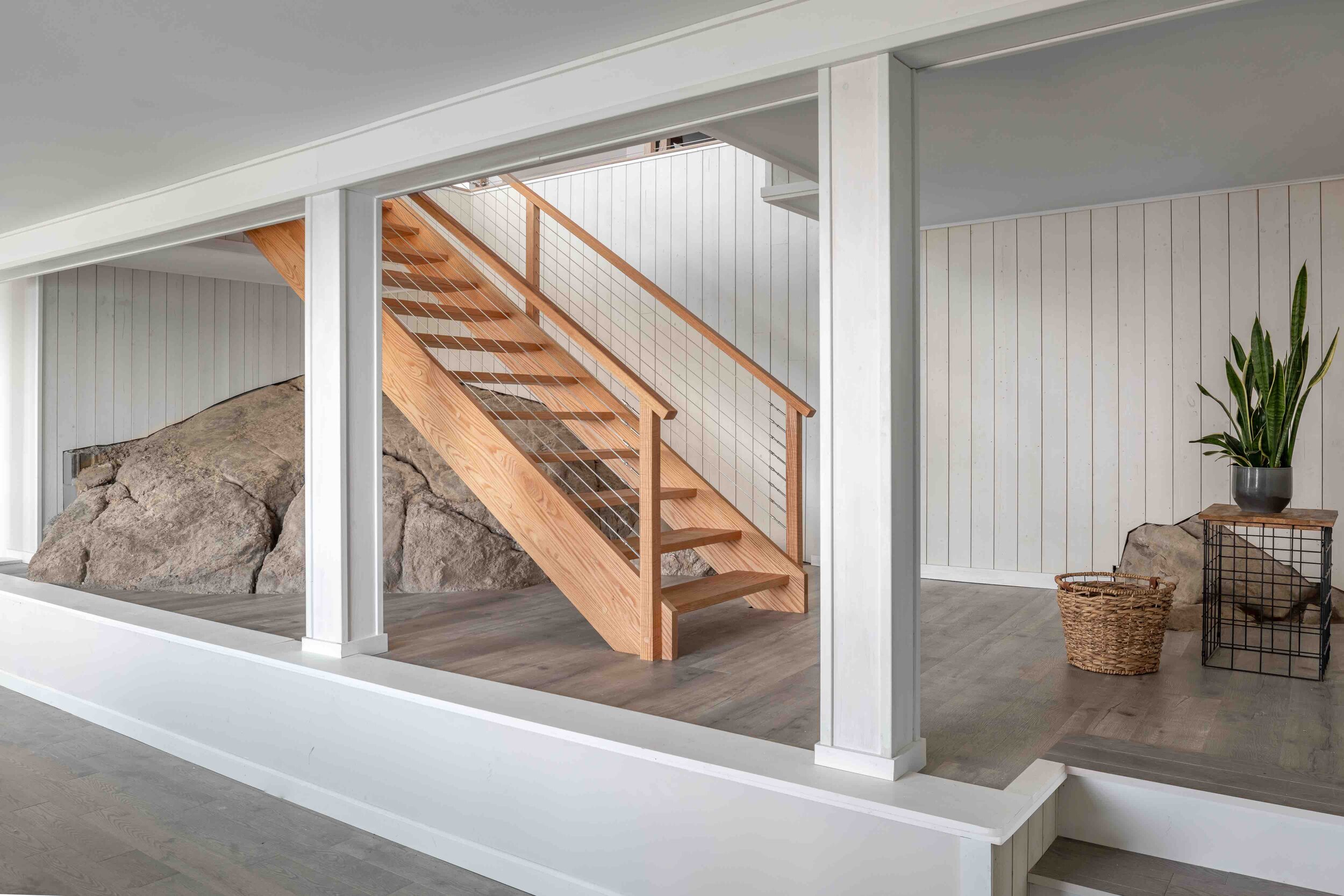  Once accessible only by a trapdoor, the refin- ished daylight basement retained one original element: an enormous boulder, which has now been decidedly rooted in the home’s foundation. 