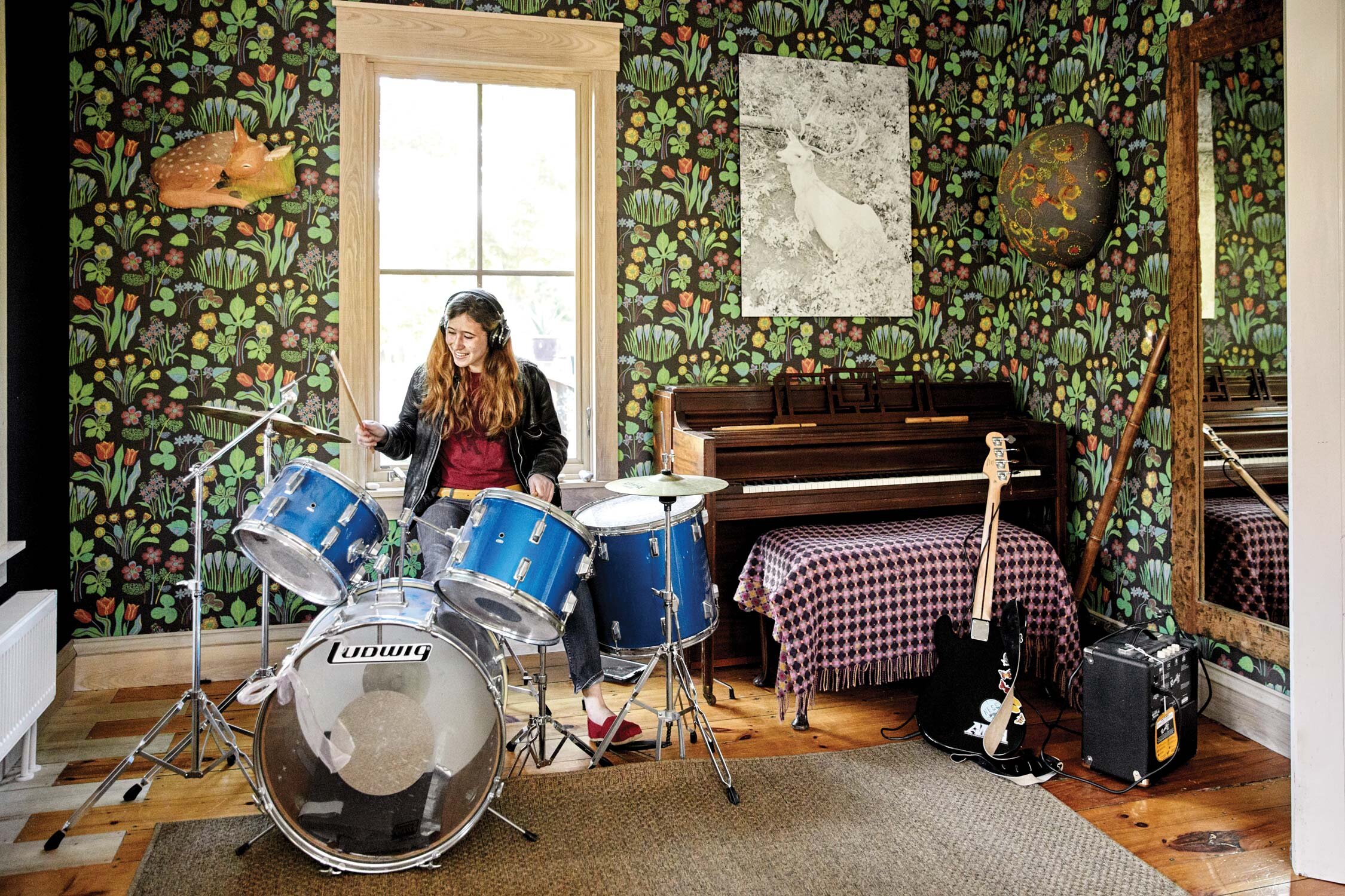 Pearl in foyer. Wallpaper by Josef Frank. Bright Deer by Dylan Hausthor. Fawn fresco by Barbara Sullivan. Nature Dome, embroidered and mixed media, by Juliet Karelsen. Accent series five-piece drum kit in classic blue sparkle by Ludwig.