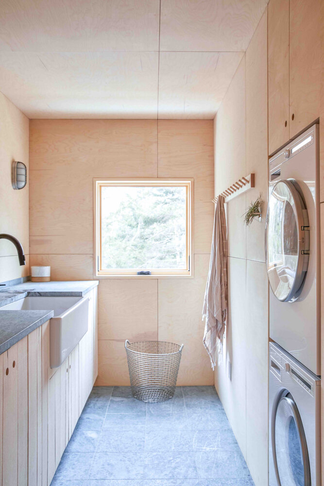  In the laundry, a stacked washer and dryer from Asko face a fireclay Shaws sink from Rohl. 