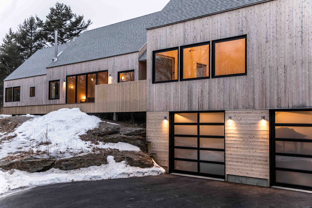  On a wintry day, the house glows warmly. The cedar-clad exterior is designed to meld with the surrounding forest. 
