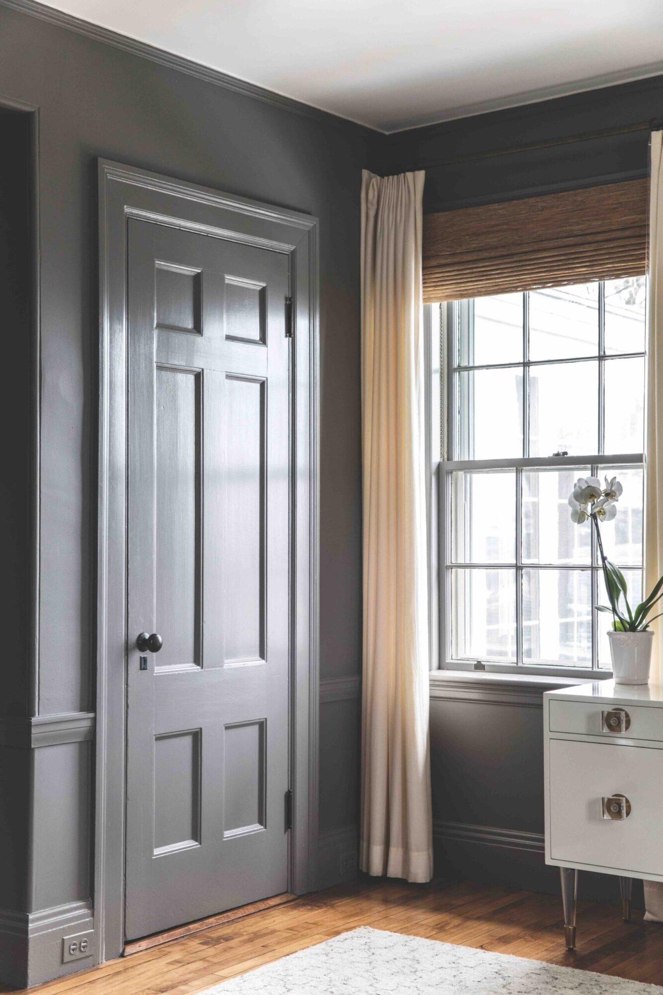 A charcoal wash for the walls, trim, and door makes a bold statement paired with earthy window treatments. Photo by Erin Little.