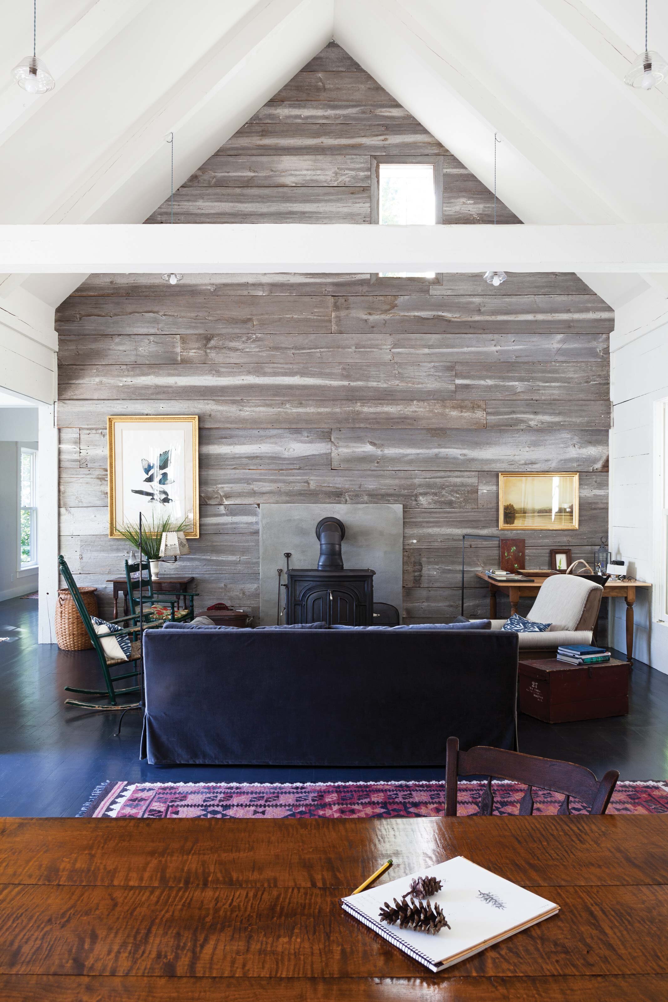  150-year-old weathered barn boards create a perfect end wall for the open living room. The photo of our property on the left is by Joyce Tenneson. 