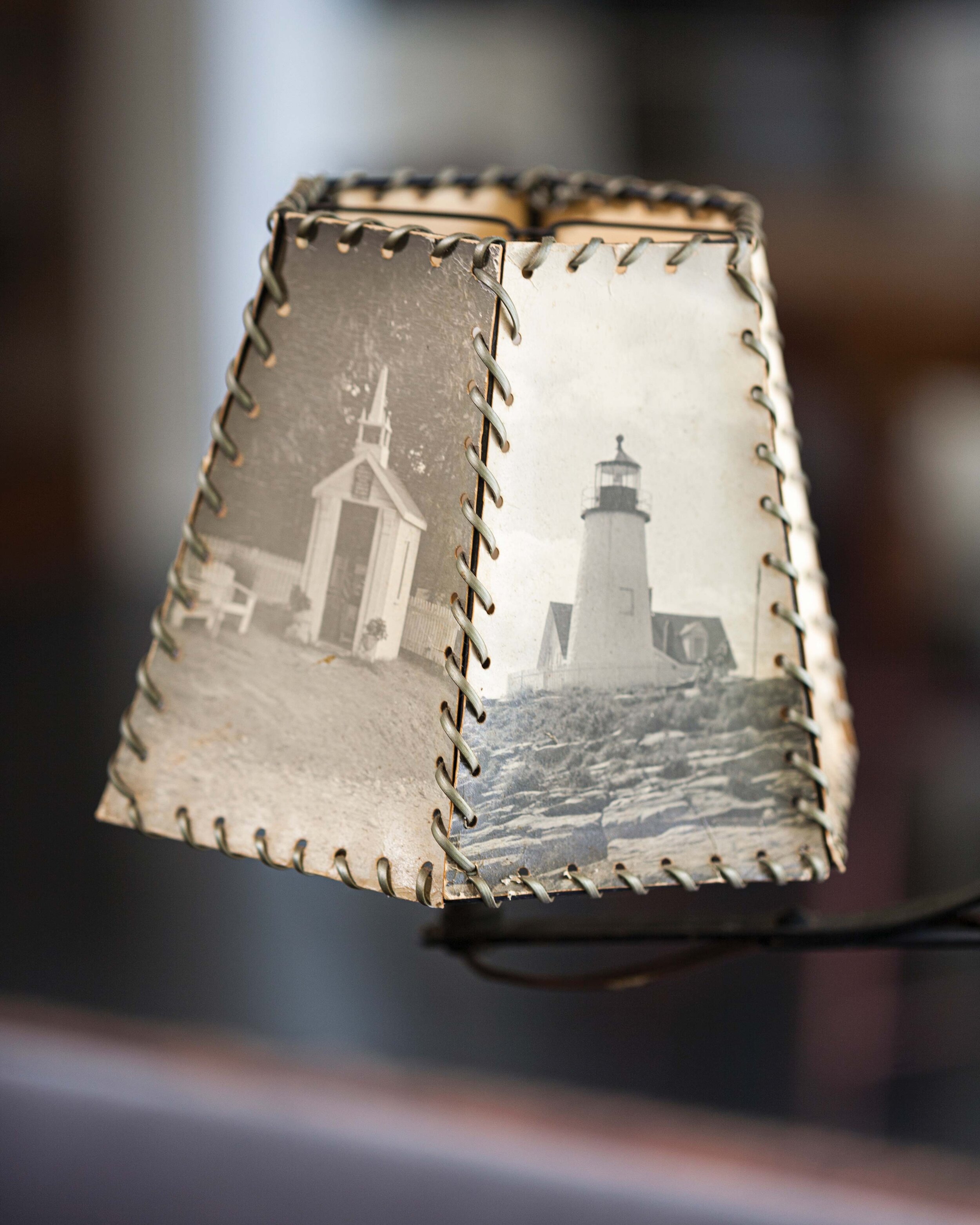  The lampshade, stitched together from vintage photographs of Maine, completes a wrought iron reading lamp. 